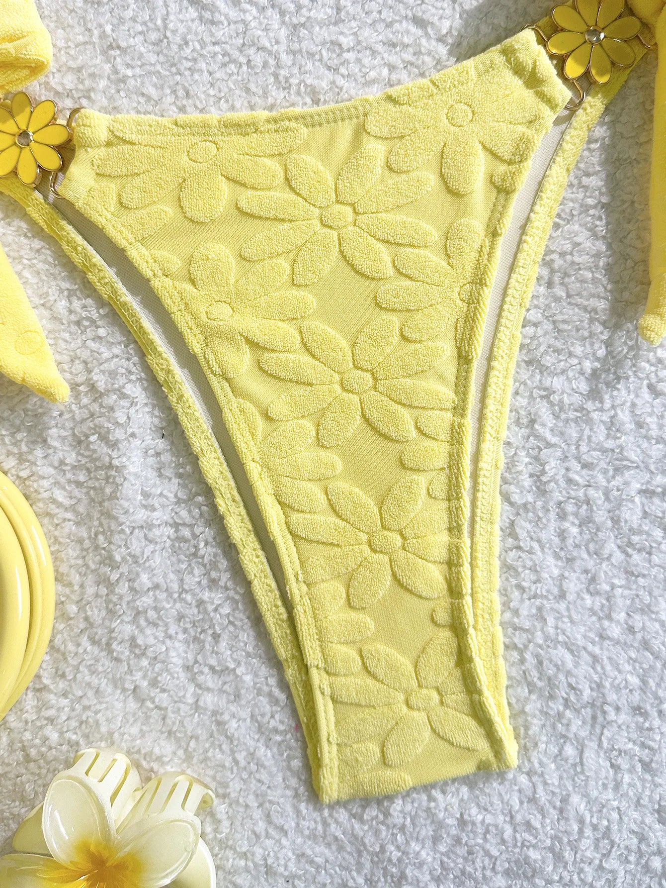 Yellow textured bikini bottom on a light gray background