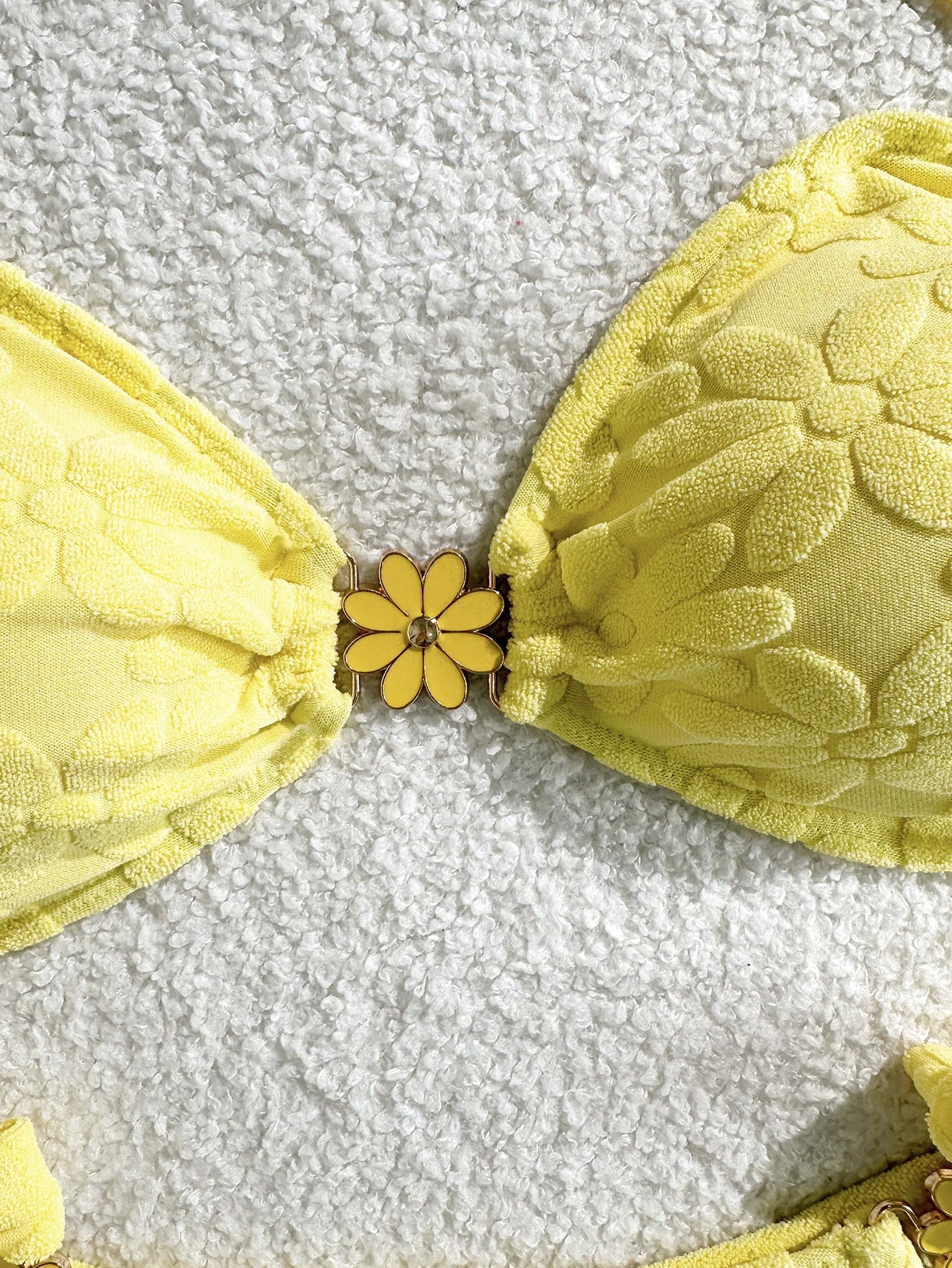 Yellow bra with floral design on a textured gray background
